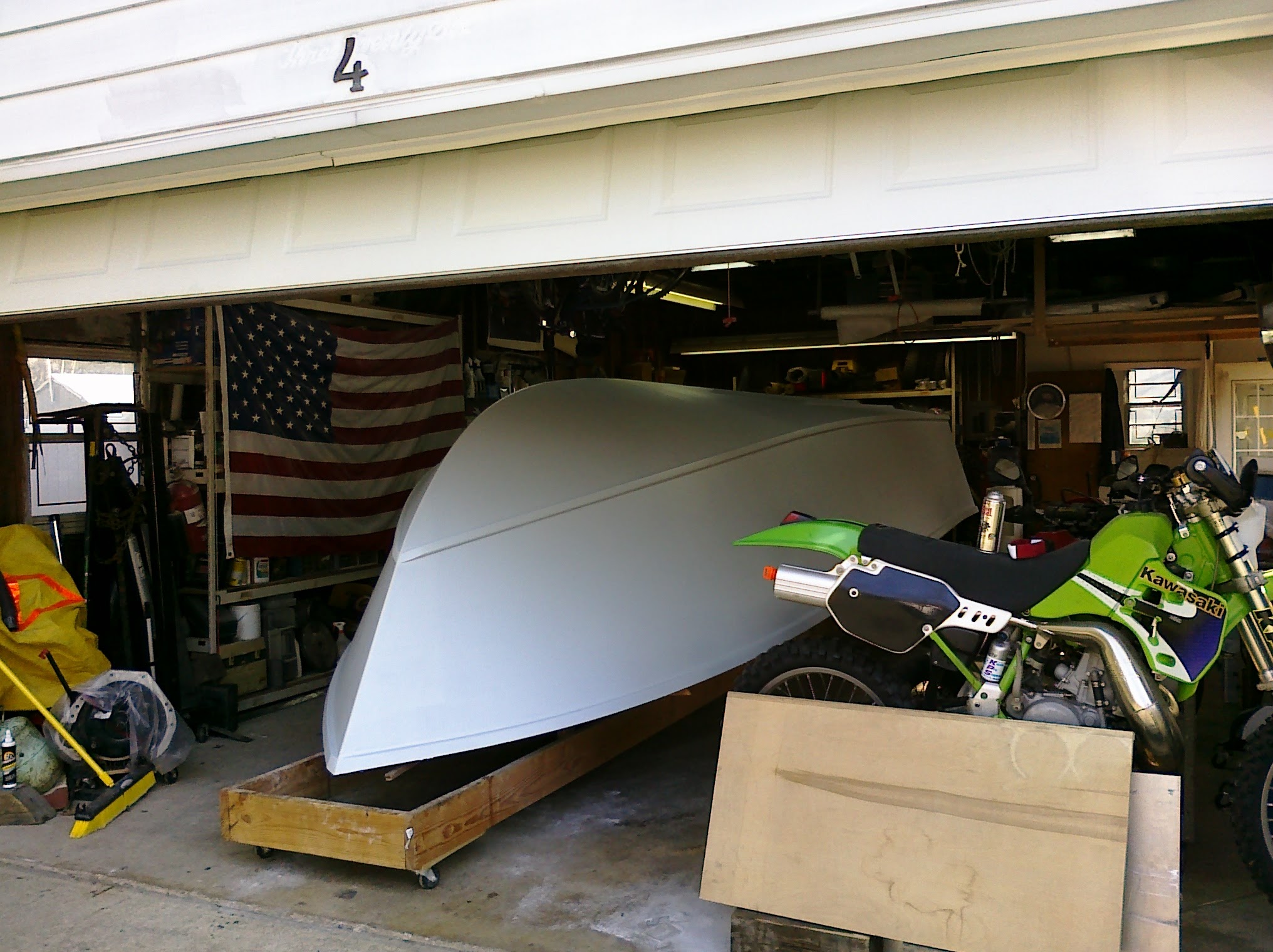 Hull in gray primer with Kawasaki in garage