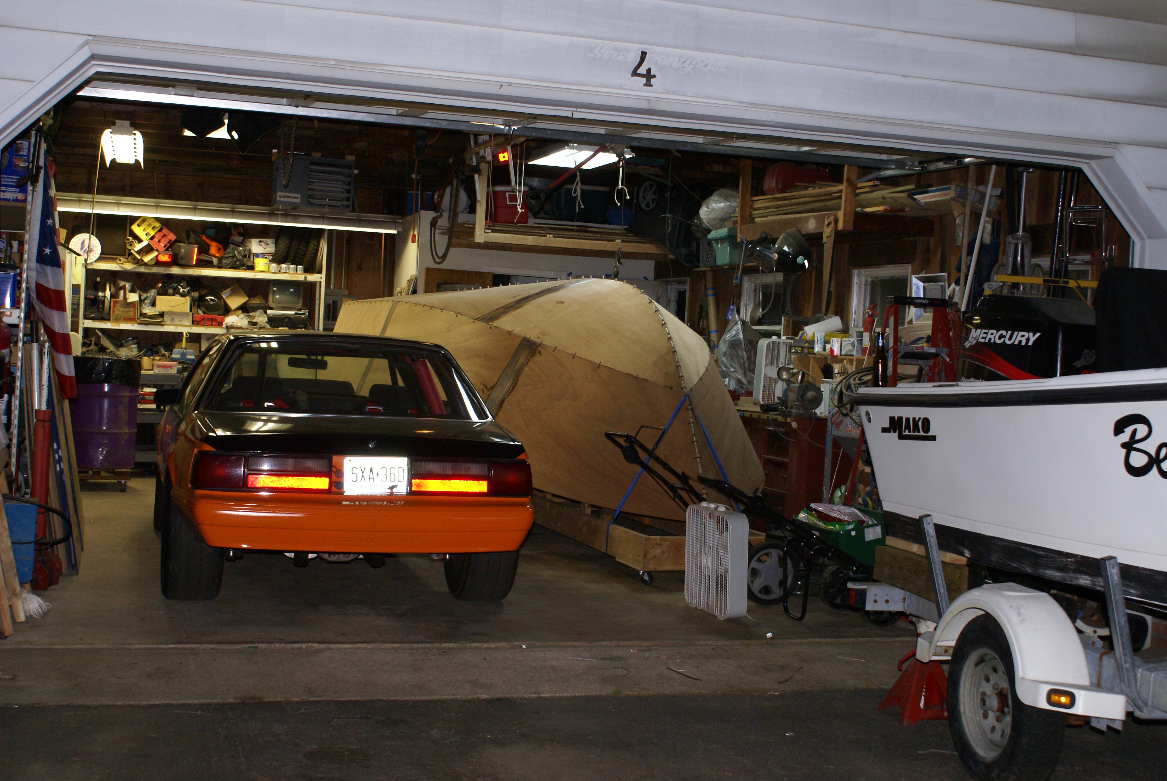 Orange 88 Mustang and stitched boat hull in same garage
