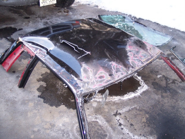 Crushed roof removed and sitting on the ground