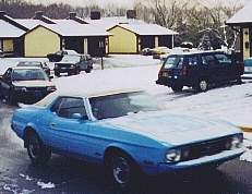 The 1973 Mustang Grande in its original blue paint, parked in the snow